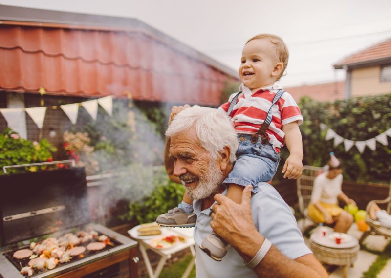 Photo of grandfather and grandson at the barbecue party