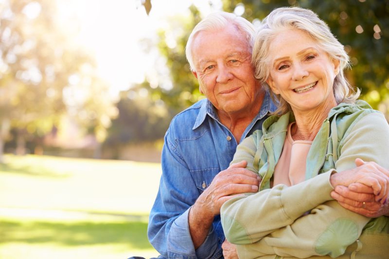 Outdoor Portrait Of Loving Senior Couple Smiling To Camera