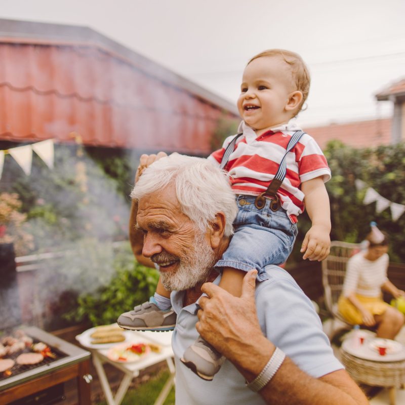 Photo of grandfather and grandson at the barbecue party