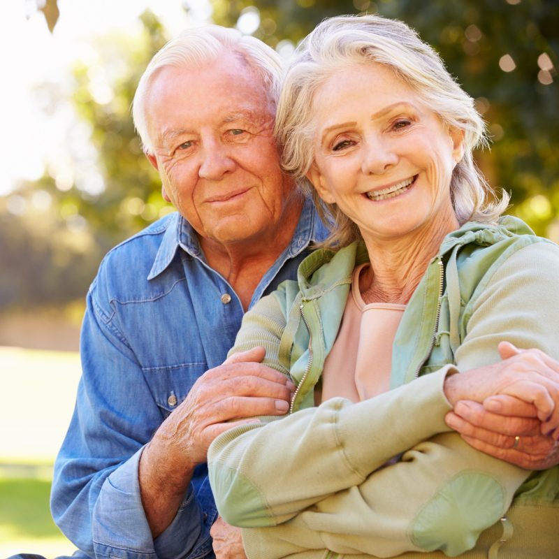 Outdoor Portrait Of Loving Senior Couple Smiling To Camera