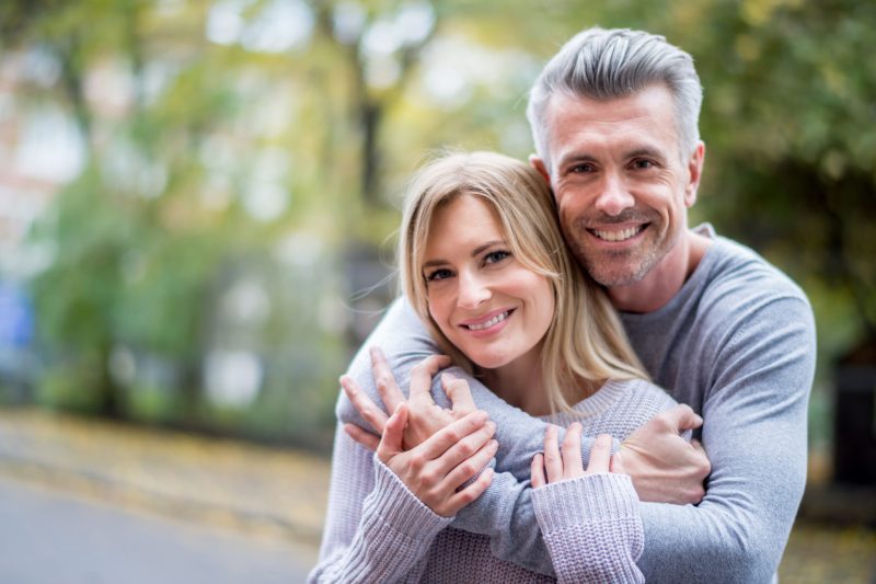 Loving couple hugging outdoors and looking happy